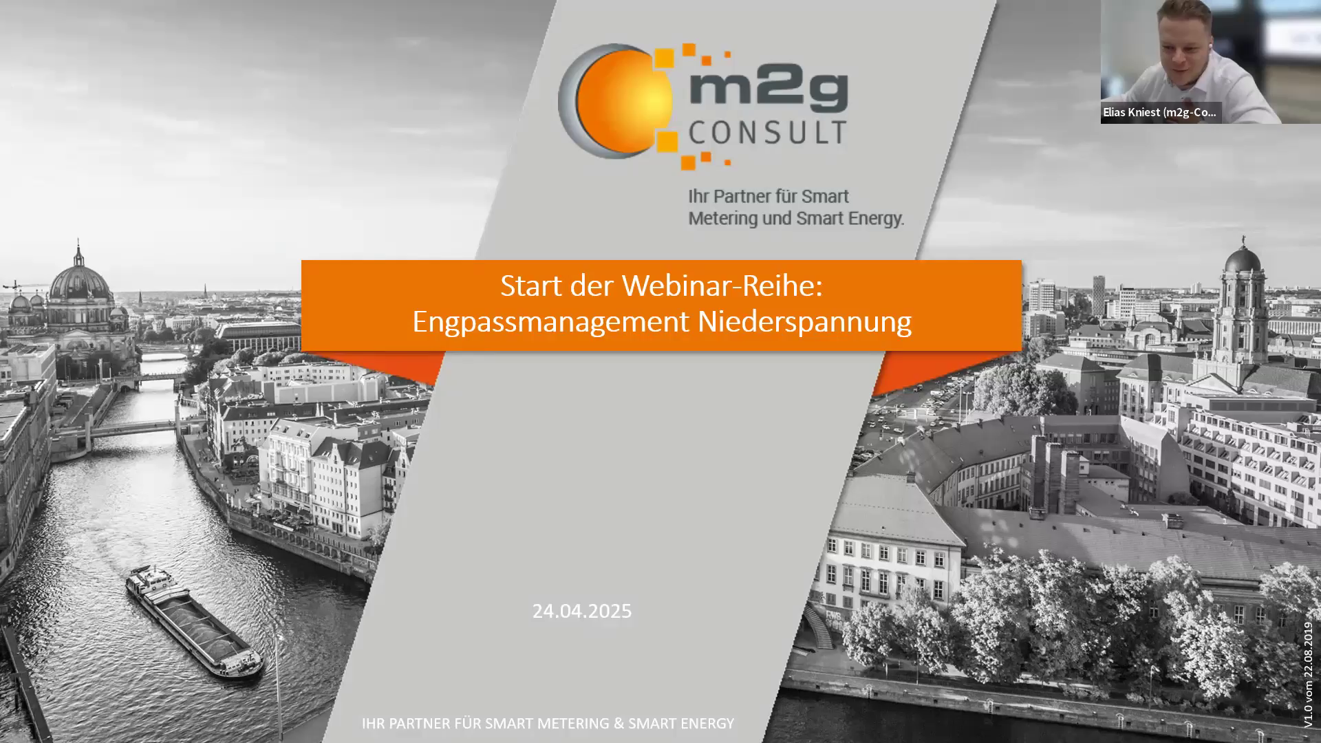 Titelfolie eines Webinars mit dem Titel „Start der Webinar-Reihe: Engpassmanagement Niederspannung“. Im Hintergrund ist eine schwarz-weiße Panoramaaufnahme von Berlin mit Spree, Berliner Dom und historischen Gebäuden zu sehen. In der Mitte befindet sich ein orangefarbener Balken mit dem Seminartitel, darüber das Logo von „m2g Consult“ und dem Zusatz „Ihr Partner für Smart Metering und Smart Energy“. Rechts oben ist ein kleines Videofenster eines Vortragenden eingeblendet. Das Datum „24.04.2025“ ist am unteren Rand angegeben.